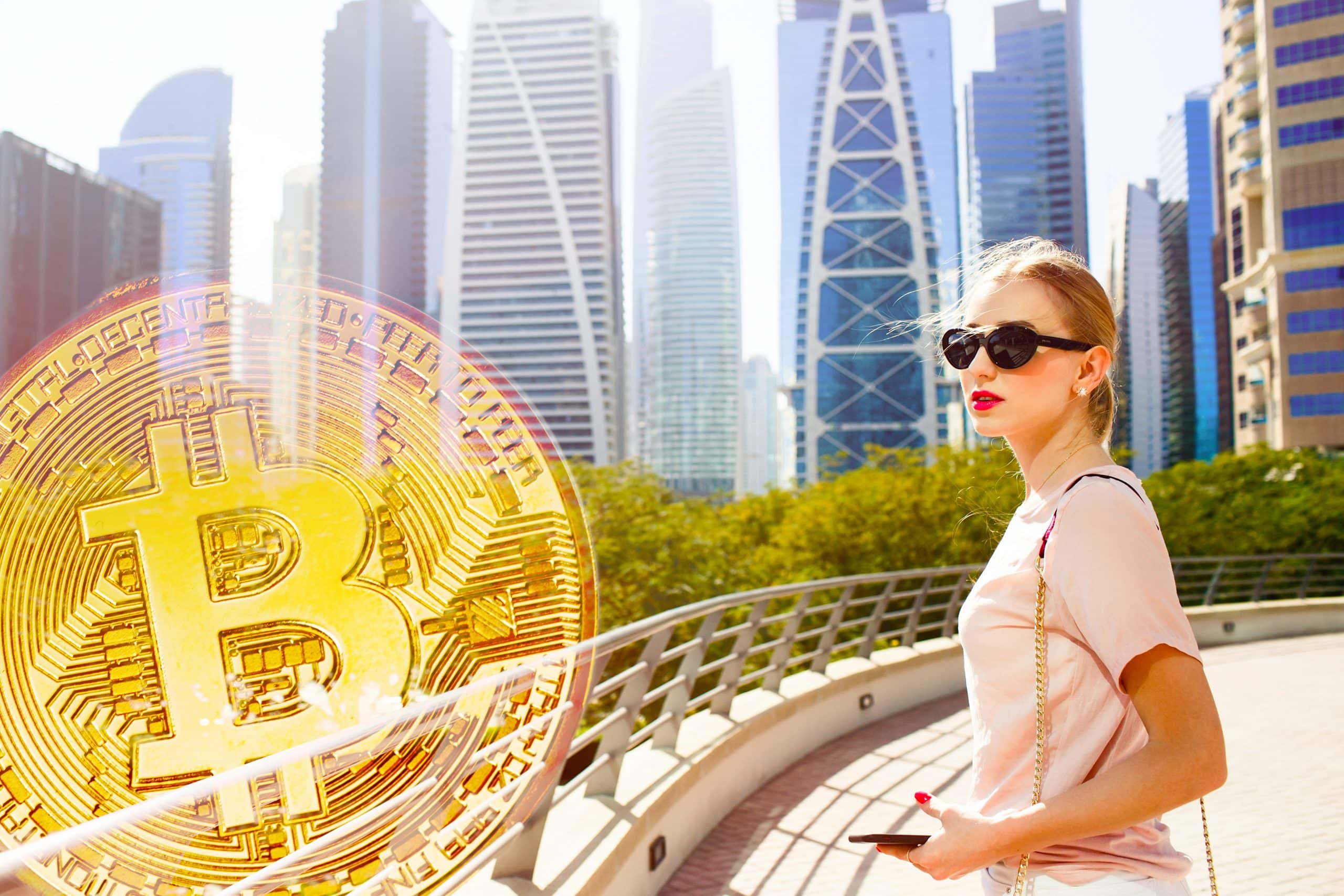 image of a woman in Dubai looking towards a digital Bitcoin cryptocurrency / NFT under the new law